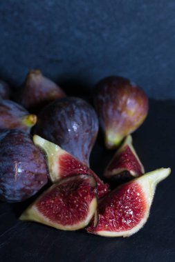 Doğal siyah incirler gruplandırılmış ve siyah arkaplanda açılır