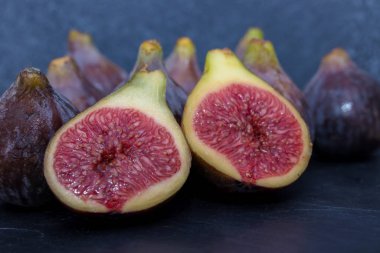 Doğal siyah incirler gruplandırılmış ve siyah arkaplanda açılır