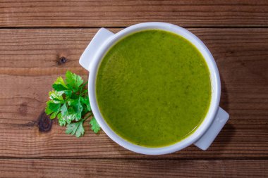 plate with soup, broth or vegetable cream on wooden background
