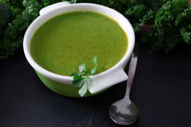 Siyah taş arka planda tabaktaki doğal sebze suyu ya da kreması.