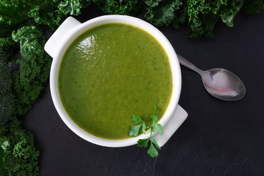 Siyah taş arka planda tabaktaki doğal sebze suyu ya da kreması.