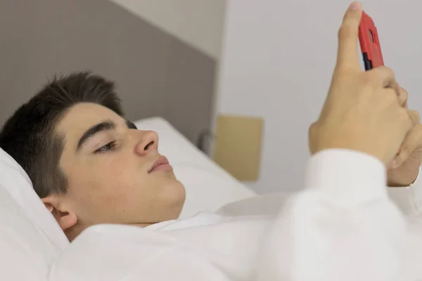 Jong Tiener Man Met Mobiele Telefoon Bed — Stockfoto