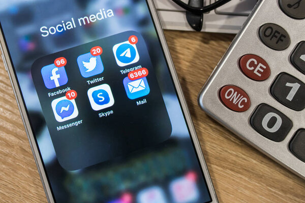 Галисия, Испания - 03 ноября 2019 года: рука с мобильным телефоном и Facebook, Twitter, Telegram, Messenger, Skype и почтовые приложения с уведомлениями
