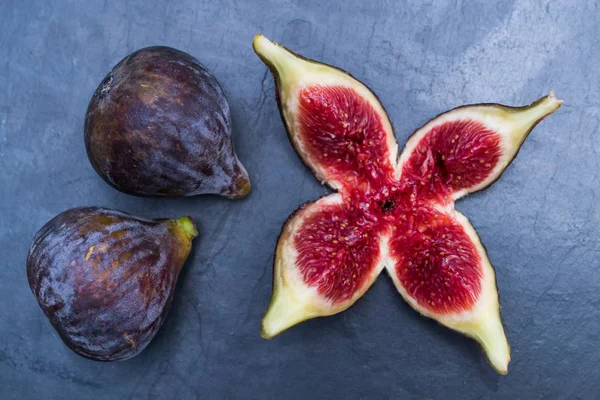 Figues Noires Naturelles Groupées Ouvertes Sur Fond Noir — Photo