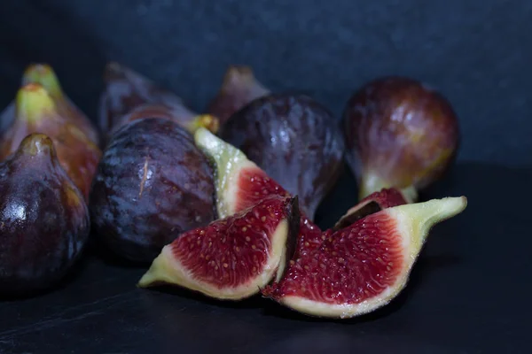 Figos Pretos Naturais Agrupados Abertos Sobre Fundo Preto — Fotografia de Stock