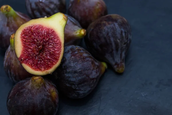 Figues Noires Naturelles Groupées Ouvertes Sur Fond Noir — Photo