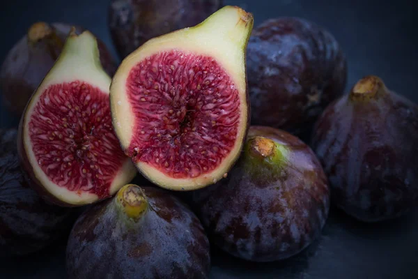 Figues Noires Naturelles Groupées Ouvertes Sur Fond Noir — Photo