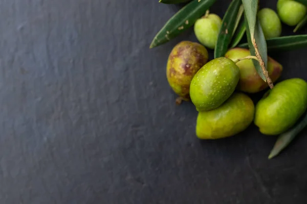 Natürliche Oliven Auf Schwarzem Stein Hintergrund Mit Olivenzweigen Und Raum — Stockfoto