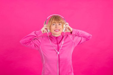 Kulaklık takmış, müzik dinleyen yetişkin ya da yaşlı bir kadın.