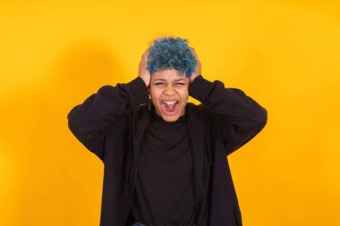 Genç Afrikalı Amerikalı kız ya da kadın sarı arka planda izole edilmiş ifade ve mavi saçlı.