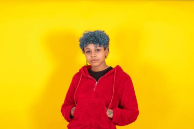 afro american girl with blue curl hair and casual style isolated on yellow background