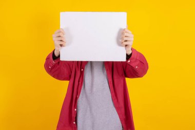 young teenager boy holding sign or signboard isolated on color background