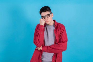 young teenage man isolated on color background with an expression of tiredness and boredom