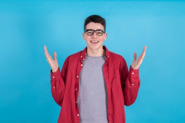 young man with happy expression and open arms isolated on color background
