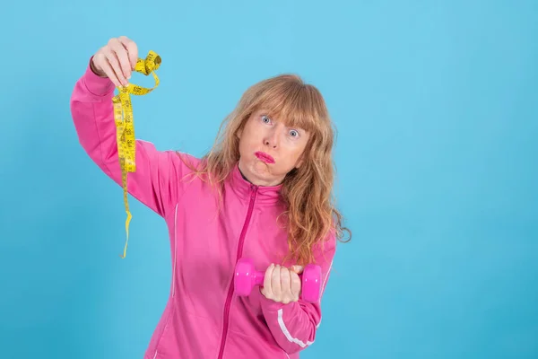 有运动服的成年妇女 以彩色背景与测量带 饮食概念和健康生活锻炼相隔离 — 图库照片