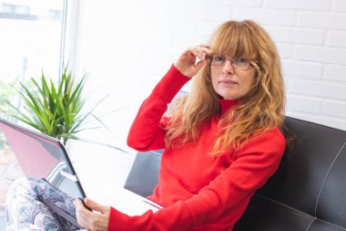 Evde ya da dairede dizüstü bilgisayarı olan bir kadın.