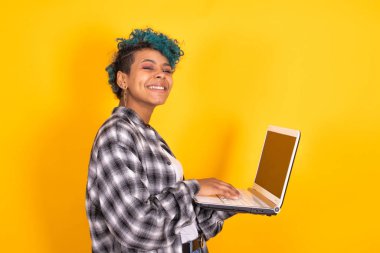 Dizüstü bilgisayarı olan kadın veya kız renk arkaplanında izole edilmiş