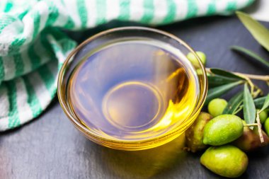 Ekstra saf zeytinyağı, zeytin dallı ve bulaşık bezli doğal zeytinler.