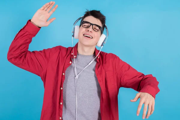 Kulaklıklı Genç Bir Çocuk Mavi Arka Planda Dans Ediyor — Stok fotoğraf