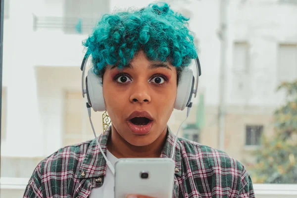 Mavi Saçlı Bir Kızın Portresi Cep Telefonuna Hayret Şaşkınlık Kulaklıkla — Stok fotoğraf