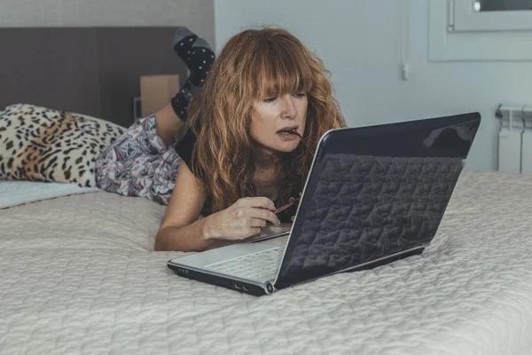 Odada Yatak Odasında Dizüstü Bilgisayarı Olan Yetişkin Bir Kadın — Stok fotoğraf