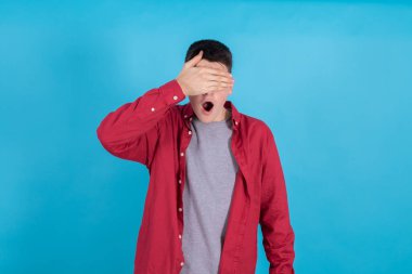 Eli ve gözlerini ve ağzını kapatan münzevi genç bir çocuk şaşkınlıkla ya da şaşkınlıkla