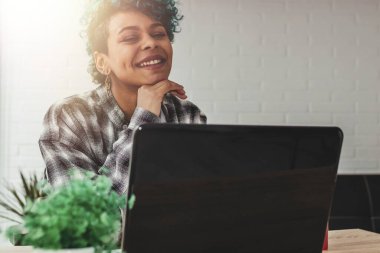 Evde ya da ofiste dizüstü bilgisayarı olan genç kız.