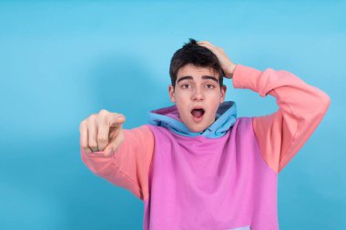 Elle işaret eden şaşkınlık ve hayranlık ifadesi olan genç ya da öğrenci çocuk.