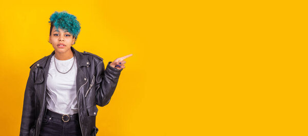 young afro american girl isolated on color background pointing space