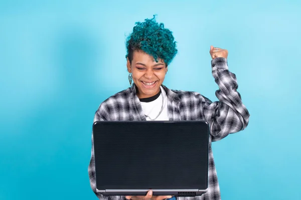 afro american girl with laptop computer isolated on blue background