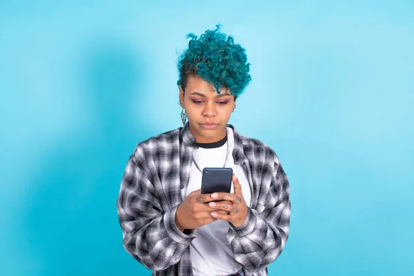 青い背景に隔離されたアフリカ系アメリカ人の少女や携帯電話やスマートフォンを持つ女性 — ストック写真