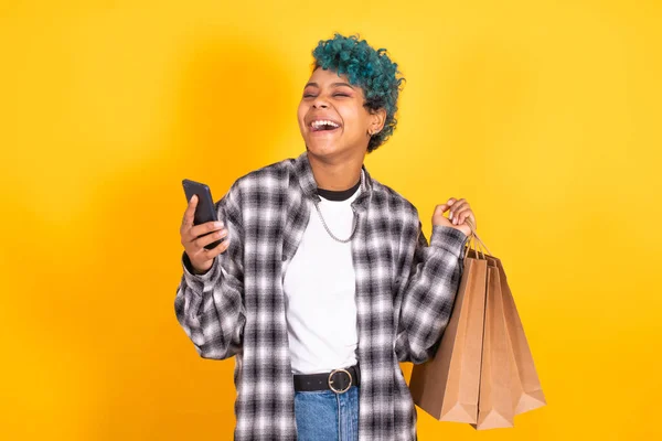 Jong Brunette Meisje Met Boodschappentassen Mobiele Telefoon Geïsoleerd Gele Achtergrond — Stockfoto