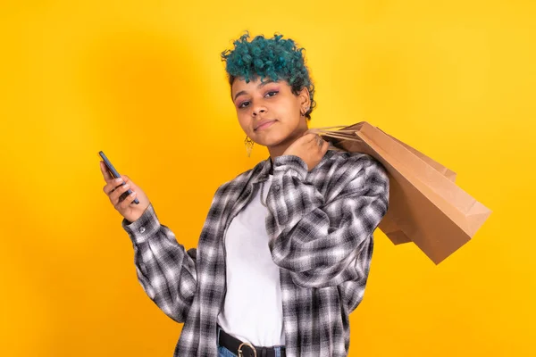 Jovem Morena Com Sacos Compras Telefone Celular Isolado Fundo Amarelo — Fotografia de Stock