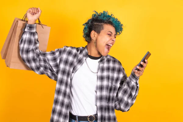 Jong Meisje Met Mobiele Telefoon Boodschappentassen Geïsoleerd Gele Achtergrond — Stockfoto