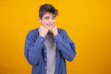 Sarı arka planda izole edilmiş genç çocuk ya da öğrenci