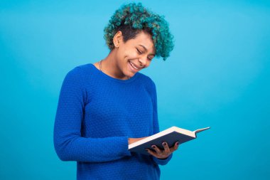 young afro american girl with book isolated on blue background clipart