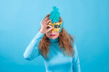 Karnaval sakızı çiğneyen yaşlı bir kadının portresi. Renkli arka plan.