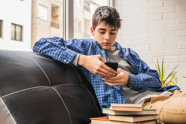 Молодий Студент Підліток Мобільним Телефоном Книгами Вдома Сидить Дивані — стокове фото