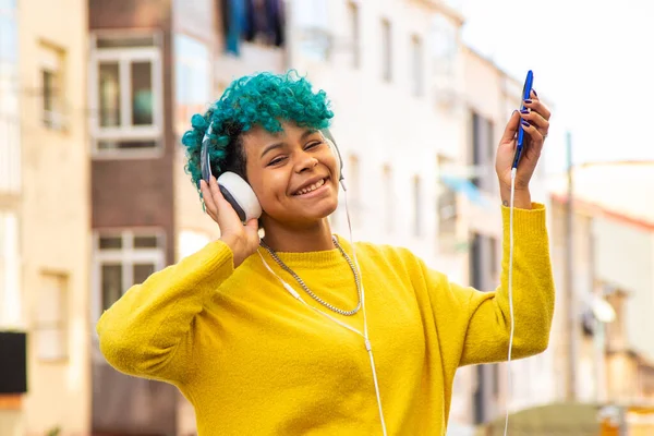 young girl with mobile phone and headphones outdoors in the city
