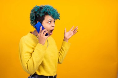 Cep telefonu olan şaşırmış bir kız ya da kadın renk arka planında izole edilmiş