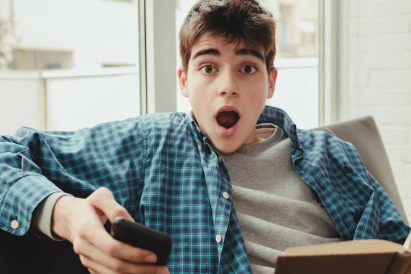 Jonge Tiener Student Met Boek Mobiele Telefoon Thuis Met Uitdrukking — Stockfoto