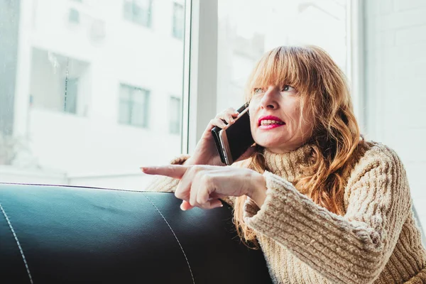 Kobieta Maską Telefon Komórkowy Siedzi Kanapie — Zdjęcie stockowe