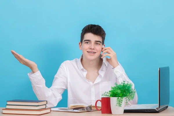 坐在办公桌前 有手机和彩色背景的青少年学生 — 图库照片