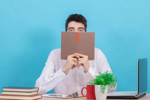 Tonårsstudent Vid Skrivbord Med Bok Framför Ansiktet — Stockfoto