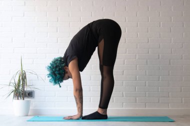 Sporcu kadın jimnastik yapıyor ya da evde ya da spor salonunda esniyor.