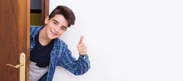 Adolescente Menino Olhando Para Fora Porta Sorrindo Com Aprovação Sinal — Fotografia de Stock