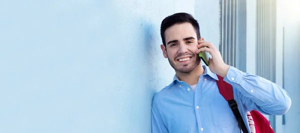 man smiling with mobile phone outdoors on the street