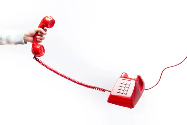 Receptor clásico de teléfono rojo en la mano — Foto de Stock