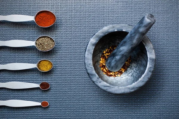 Kaşık ve harç ve havaneli ile baharat mutfak masasında ölçme