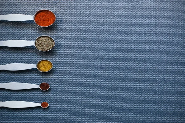 Baharat kaşıklarla ölçme başka bir mutfak masasının üzerinde yukarıda düzenlenmiş 